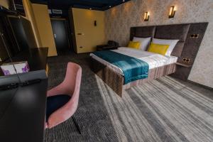 Habitación de hotel con 1 cama y 2 sillas rosas en HOTEL LOBBY, en Bihać