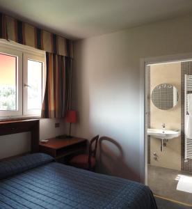 een hotelkamer met een bed en een wastafel bij Cravero Rooms in Caltignaga
