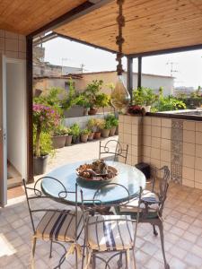 eine Terrasse mit einem Glastisch und Stühlen auf einer Terrasse in der Unterkunft The Heart of Naples - Neapolitana in Neapel