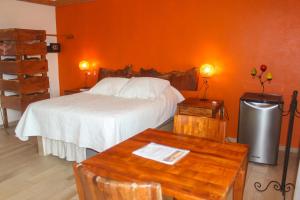 1 dormitorio con 1 cama con pared de color naranja en Villa Los Corales, en Sayulita