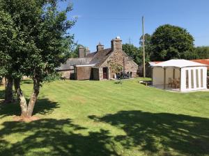 an old stone house with a tent and a yard at The Annex at Middle Filham, Ivybridge in Ivybridge