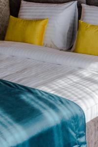 比哈奇的住宿－HOTEL LOBBY，一张配有黄色和蓝色床单和枕头的床