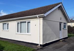 a white house with a gambrel roof at 2 bedroom Chalet all to yourself, free parking, dogs welcome in Swansea