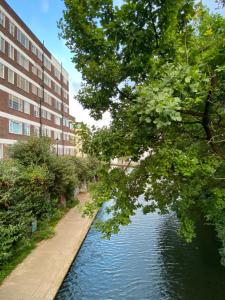 un canale in una città con un edificio e alberi di Camden Royale Apart a Londra