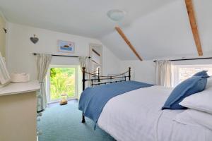 Un dormitorio con una cama grande y una ventana en Finest Retreats - Waterside Cottage en Nancledra