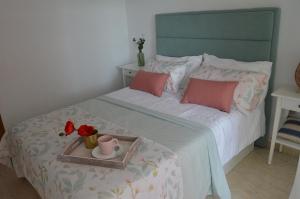 a bedroom with a bed with a tray with flowers on it at Espectacular apartment con piscina, vistas al mar y tranquilidad 10 min desde Valencia in Puebla de Farnals