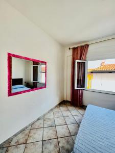 a bedroom with a mirror on the wall at Appartamento La Baia in Fetovaia