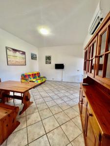 een woonkamer met een tafel en een bank bij Appartamento La Baia in Fetovaia