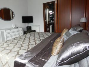 Un dormitorio con una cama grande con almohadas doradas. en Casa Daniel, en Riberas del Sor