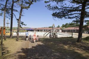 a family walking through a park with a playground at Sier aan Zee in Hollum