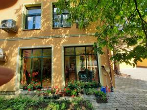 a building with a bunch of flowers in front of it at Ágnes Vendégház in Tokaj