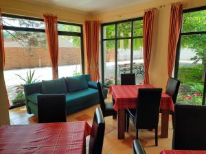 a living room with a couch and tables and windows at Ágnes Vendégház in Tokaj +13 photos