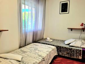 two beds sitting in a room with a window at APARTMENT IVANA in Brodarica