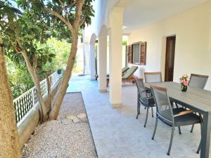 a patio with a table and chairs and a tree at APARTMENT IVANA in Brodarica