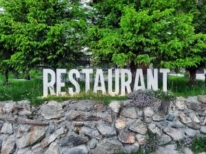 Pensiune & Restaurant Victoria في بالتينيس: علامة على قمة جدار حجري