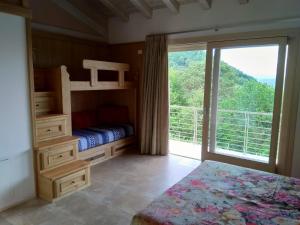 ein Schlafzimmer mit einem Etagenbett und einem großen Fenster in der Unterkunft Locazione turista Cocodè in Miane