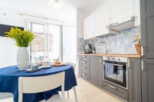 een keuken met een tafel met een blauwe tafeldoek erop bij Baia Marzamemi appartamenti Vendicari, Balata, Tonnara, Cortile del Rais in Marzamemi