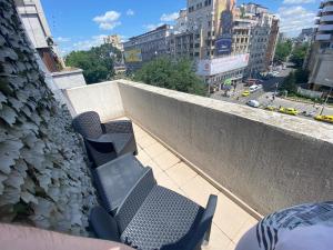 un groupe de chaises sur un balcon d'un bâtiment dans l'établissement Bucarest B&B, à Bucarest