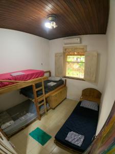 a room with two bunk beds and a window at Habitat Marajó Hostel in Soure