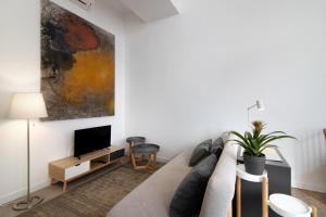 a living room with a couch and a tv at Casa Vermelha ii in Faro