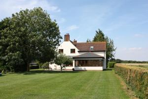 a white house with a large grass yard at Puttocks Farm in Great Dunmow