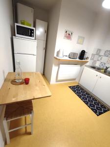 a small kitchen with a table and a refrigerator at Grand appartement en RDC Vallée de Campan in Campan