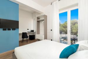 a bedroom with a white bed and a large window at Nelli Rooms Via Veneto in La Spezia