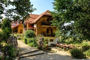 uma casa de madeira com uma mesa de piquenique em frente em House Mrzlin Grad em Korenica