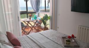 a bedroom with a bed and a balcony with a table at Espectacular apartment con piscina, vistas al mar y tranquilidad 10 min desde Valencia in Puebla de Farnals