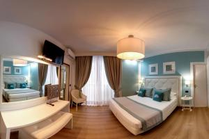 ein Schlafzimmer mit einem großen Bett mit blauen Wänden in der Unterkunft Raffaelli Park Hotel in Forte dei Marmi