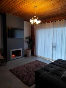 uma sala de estar com um sofá e uma lareira em Refúgio Altos do Campestre - TURISMO RURAL em Urubici