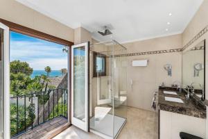 a bathroom with a view of the ocean at All About Puente Romano Penthouse Suite in Marbella