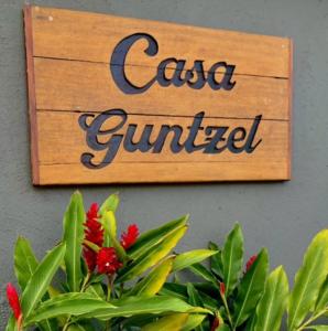 a sign that reads caffe gourmet on a wall with flowers at Pousada Casa Guntzel in Juquei