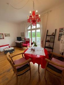 ein Wohnzimmer mit einem Tisch, Stühlen und einem Kronleuchter in der Unterkunft romantische Ferienwohnung Sachsenhof 4 in Klingberg