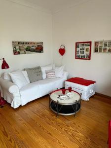 ein Wohnzimmer mit einem weißen Sofa und einem Tisch in der Unterkunft romantische Ferienwohnung Sachsenhof 4 in Klingberg