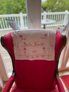 a red chair with a napkin on the back of it at romantische Ferienwohnung Sachsenhof 4 in Klingberg