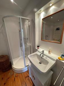 baño blanco con ducha y lavamanos en romantische Ferienwohnung Sachsenhof 4, en Klingberg
