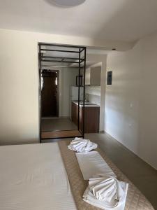a bedroom with a large white bed and a bathroom at Zinozis Beach Apartments in Vourvourou