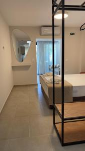 a bedroom with a bunk bed and a mirror at Zinozis Beach Apartments in Vourvourou