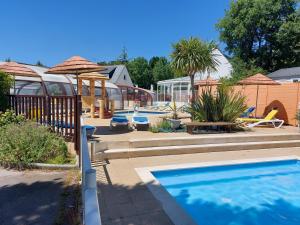 - une piscine avec parasols dans une cour dans l'établissement CARNAC Mobil-Home Camping 4 étoiles, à Carnac