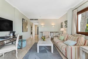 a living room with a couch and a table at All About Puente Romano Penthouse Suite in Marbella