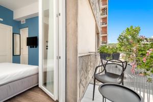 a room with a balcony with two chairs and a bed at Nelli Rooms Via Veneto in La Spezia