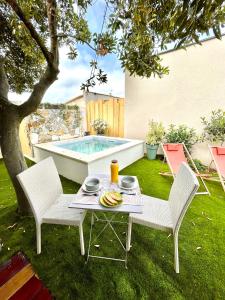 uma mesa e duas cadeiras num quintal com piscina em Studio Piscine Balnéo Chauffée em Sérignan