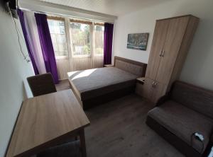 a small room with a bed and a table at OZone Apartman in Siófok