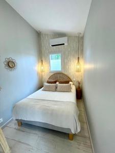 a bedroom with a large white bed with two pillows at Studio Piscine Balnéo Chauffée in Sérignan +13 photos