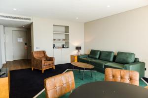 a living room with a green couch and chairs at Octant Ponta Delgada in Ponta Delgada