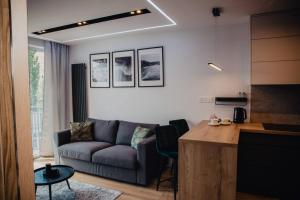 een woonkamer met een bank en een tafel bij JBHotels Apartament Prestige in Szczecin
