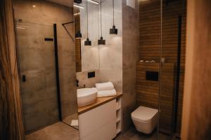 シュチェチンにあるJBHotels Apartament Prestigeのトイレ、洗面台、シャワー付きのバスルーム +15枚の写真