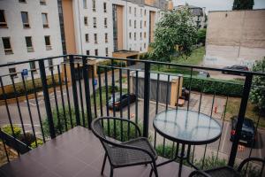 een balkon met een tafel en stoelen en een straat bij JBHotels Apartament Prestige in Szczecin