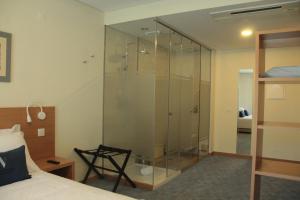 a glass shower in a bedroom with a bed at Hotel da Vila in Manteigas +37 photos
